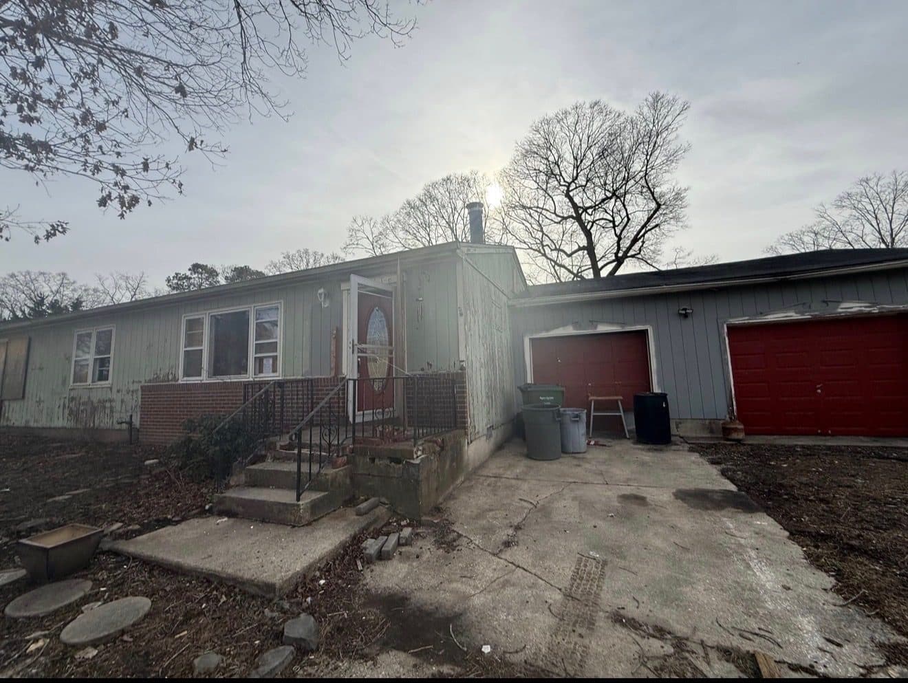 Before: the ranch house with peeling paint, a broken front step and faded garage doors